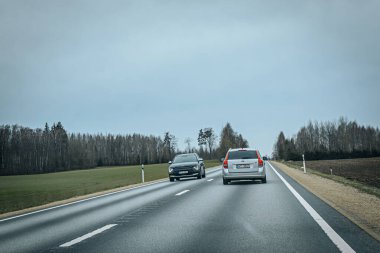 Bahar döneminde araba trafiği olan Valmiera Riga yolu. Ana caddelerdeki Riga binaları. 