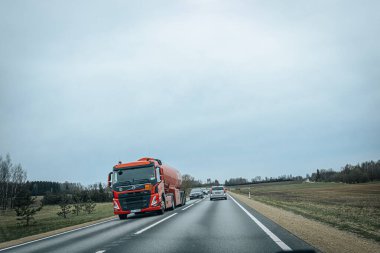 Bahar döneminde araba trafiği olan Valmiera Riga yolu. Ana caddelerdeki Riga binaları. 