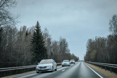 Bahar döneminde araba trafiği olan Valmiera Riga yolu. Ana caddelerdeki Riga binaları. 