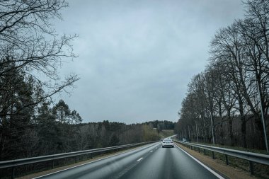 Bahar döneminde araba trafiği olan Valmiera Riga yolu. Ana caddelerdeki Riga binaları. 