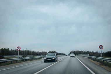 Bahar döneminde araba trafiği olan Valmiera Riga yolu. Ana caddelerdeki Riga binaları. 