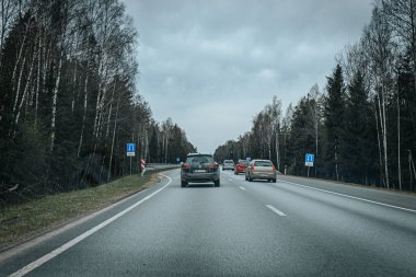 Bahar döneminde araba trafiği olan Valmiera Riga yolu. Ana caddelerdeki Riga binaları. 