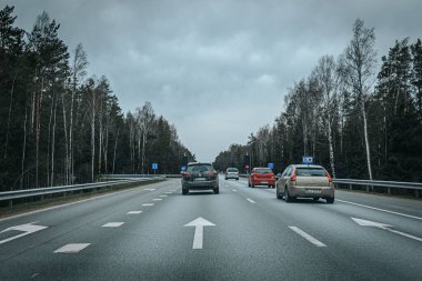 Bahar döneminde araba trafiği olan Valmiera Riga yolu. Ana caddelerdeki Riga binaları. 