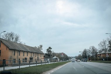 Bahar döneminde araba trafiği olan Valmiera Riga yolu. Ana caddelerdeki Riga binaları. 