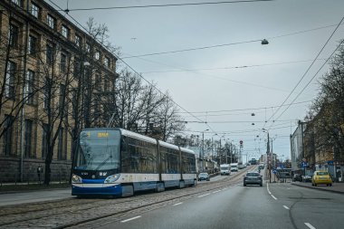 İlkbahar döneminde tramvay ve tramvay hatları olan Riga şehir yolu. Ana caddelerdeki Riga binaları.