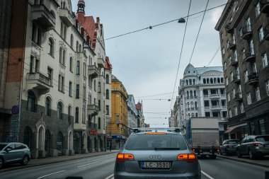 Bahar döneminde araba trafiği olan Valmiera Riga yolu. Ana caddelerdeki Riga binaları.