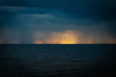 Deniz kıyısında gün batımlı taşlar. Yumuşak seçici odaklanma. Resim için yapay olarak tahıl oluşturuldu