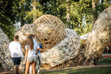 Parkta topun geometrik merkezi parçası olan büyük bir İtalyan ahşap heykeli. Karmaşık tasarım arka planda duruyor.. 