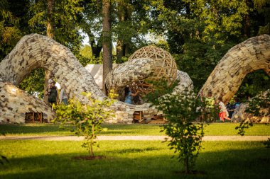 Parkta topun geometrik merkezi parçası olan büyük bir İtalyan ahşap heykeli. Karmaşık tasarım arka planda duruyor.. 