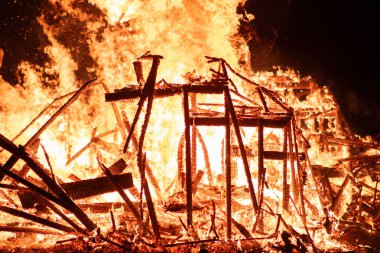 Ahşap yapı gece boyunca tamamen alevlerle kaplıydı. Şiddetli ateş tüm kareyi yutar ve yangının yıkıcı gücünü vurgular..