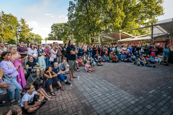 Çocuklar ve yetişkinler de dahil olmak üzere çeşitli insanlar kültürel performansı dikkatle izliyorlar.. 