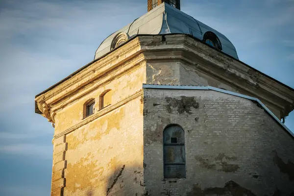 stock image The historic tower of the Valmiermuia castle with a distinctive dome and spire standing against a clear blue sky with light clouds. The structure showcases old stone and detailed architecture.