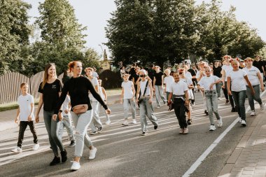 Bir grup insan, canlı bir şehir ortamında mesajlarını ifade eden pankartlar taşıyan bir şehir festivaline katılıyor. Sahne, arka planda çeşitli bir kalabalıkla festivalin enerji ve nişanını yakalıyor.. 