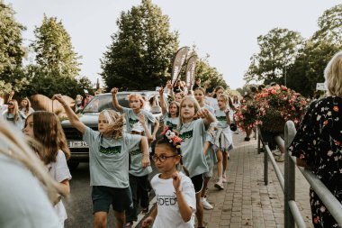 Bir grup insan, canlı bir şehir ortamında mesajlarını ifade eden pankartlar taşıyan bir şehir festivaline katılıyor. Sahne, arka planda çeşitli bir kalabalıkla festivalin enerji ve nişanını yakalıyor.. 