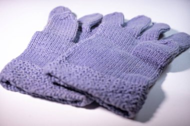 Mor örgü eldivenlerin yakın plan görüntüsü, desenlerini ve yumuşak materyallerini gösteriyor. Eldivenler beyaz arka plana yerleştiriliyor..