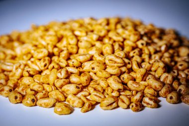 Parlak bal kaplamalı altın çiçekli mısır gevreği beyaz bir tabağa konur. Çıtır çıtır ve iştah açıcı görünümünü vurgular..