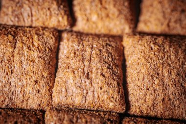 Kahverengi mısır gevreği karelerinin düzenli bir şekilde sıralanması, çıtır çıtır dokularını ve sağlıklı görünümlerini vurguluyor..