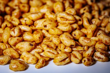 Beyaz arkaplana saçılmış altın kabarık mısır gevrekleri kopyası için bolca yer bırakıyor. Balla kaplanmış dokusu ışıkta parlıyor, çıtırtısını vurguluyor..