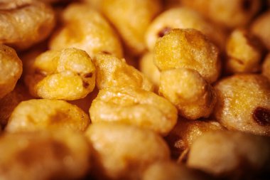 Parlak, bal kaplı dokuları olan ve çıtırtılarını ve detaylarını vurgulayan altın kaplama mısır gevreği parçaları..