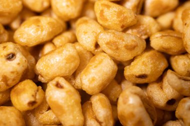 Parlak, bal kaplı dokuları olan ve çıtırtılarını ve detaylarını vurgulayan altın kaplama mısır gevreği parçaları..