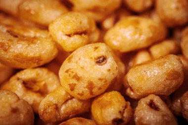 Parlak, bal kaplı dokuları olan ve çıtırtılarını ve detaylarını vurgulayan altın kaplama mısır gevreği parçaları..