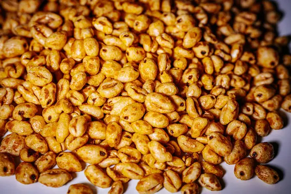 Beyaz arkaplana saçılmış altın kabarık mısır gevrekleri kopyası için bolca yer bırakıyor. Balla kaplanmış dokusu ışıkta parlıyor, çıtırtısını vurguluyor..