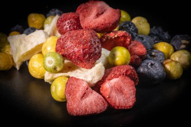 Kuru erik, kızılcık ve balkabağı parçaları da dahil olmak üzere çeşitli kurumuş meyvelerin yakın plan çekimlerinde canlı renkleri ve dokuları vurgulanıyor..