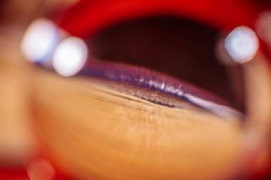 Yumuşak pembe ve turuncu dairesel ışık desenleri ve pürüzsüz, dalgalı dokusu olan kitapların soyut yakın plan görüntüleri. Kompozisyon rüya gibi ve hipnotik bir görsel etki yaratıyor. Görünür pencerelerden.