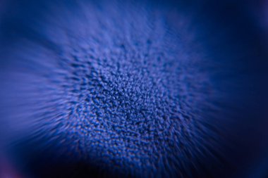 Derin mavi tonlarda radyal bulanık efektli yüzeyin yakın çekim makro görüntüsü dinamik ve soyut bir görsel yaratıyor. Yumuşak odak derinlik duygusunu arttırır..