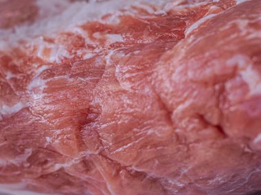 Beyaz bir tabağa konmuş taze, çiğ domuz pirzolası. Zengin doku ve doğal renk etin kalitesini vurgular, pişirilmeye hazır..