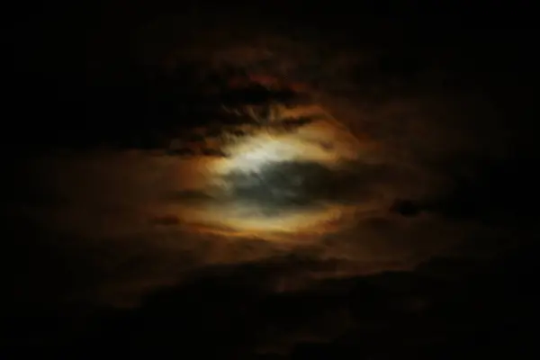 Koyu bulutlu loş bir gökyüzü turuncu ve mavinin hafif yanardöner tonlarını ortaya çıkararak ürkütücü, göksel bir ışıltıyla karamsar ve atmosferik bir sahne yaratıyor..