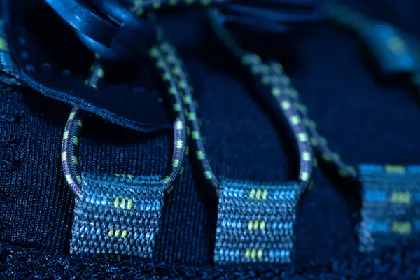  Siyah atletik bir ayakkabının üzerinde, hızlı ayarlama için sarı çizgili ipler ve plastik bağlayıcıların yer aldığı kauçuk stili elastik bağlama sisteminin ayrıntılı görünümü.