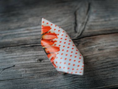 Kırmızı laleli beyaz kağıtlar ve ahşap bir yüzeye yerleştirilmiş küçük kırmızı kalpler. Yumuşak ışıklandırma ve geniş kopyalama alanı.