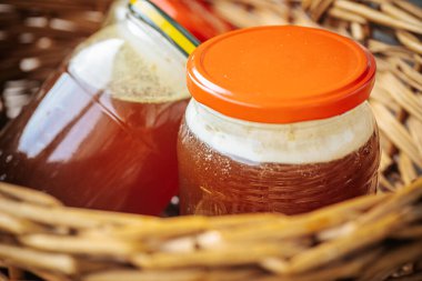 Kehribar balı ile doldurulmuş birkaç cam kavanoz sade bir hasır sepete konur. Doğal ve ev yapımı bir cazibe sergilerler..