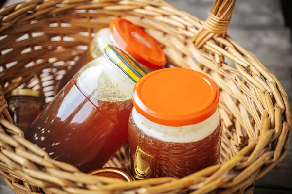 Kehribar balı ile doldurulmuş birkaç cam kavanoz sade bir hasır sepete konur. Doğal ve ev yapımı bir cazibe sergilerler..