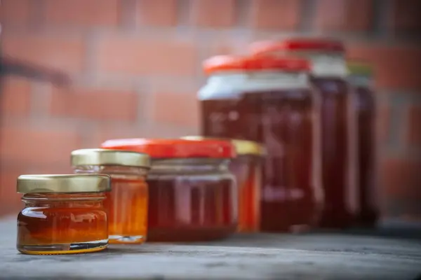 Kehribar balı ile doldurulmuş birkaç cam kavanoz sade bir hasır sepete konur. Doğal ve ev yapımı bir cazibe sergilerler..