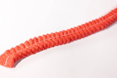 Kırmızı, buruşuk, tek kullanımlık saç bantlarının yakın plan görüntüsü beyaz arka planda görünür doku ve dikişleri var..