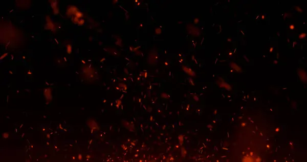 Ateşten kıvılcımlar ve kömürler saçıyor. Siyah arka planda yanan ateş ve duman parçacıkları, şenlik ateşi.