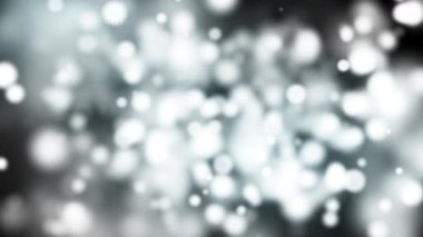 Gri bir zemin üzerinde yüzen soyut yumuşak beyaz bokeh ışık parçacıkları. Hafifçe hareket eden parlak halkalar, şenlikli, zarif, kış, düğün ve rüya gibi atmosfer video projeleri için ideal.