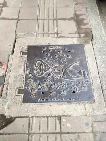 Manhole Cover art images, street in Pattaya, Thailand.Translation: 1.Pattaya City 2.Pattaya City 3.It is illegal to possess this manhole.