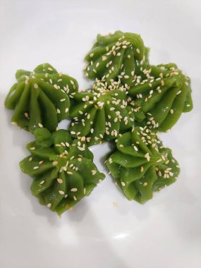 Tayland usulü pandan pudingi üzerine kızarmış susam ve konsantre hindistan cevizi sütü.. 