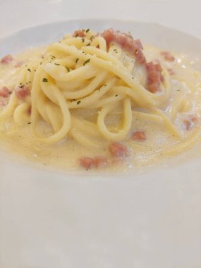Bangkok Tayland 'da beyaz tabakta kremalı jambonlu carbonara..
