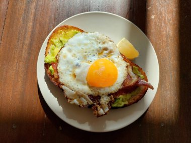 Khao Yai manzaralı bir tabak yumurta, pastırma ve avokado tostu..