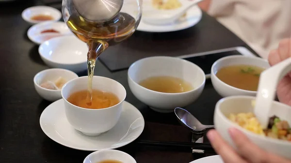 Çay demliği ve çay fincanı yemek masasında, Kanton mutfağı Bangkok 'ta..
