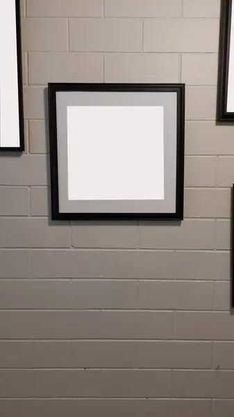 Black frame mockups display on a brick wall.