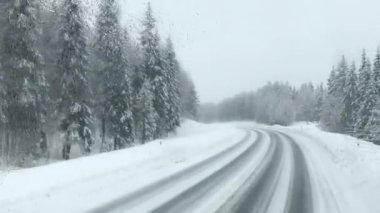 Finlandiya, Rovaniemi 'de otobüsün ön camından karlı bir yol uzanır..