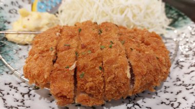 Japon Pork Katsu, kızarmış domuz pirzolası ve ekmeği olan popüler bir yemektir. Genellikle doğranmış lahana ve pirinçle servis edilir..