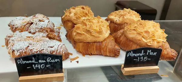 stock image Almond croissants and almond au rum croissants on display in the bakery.