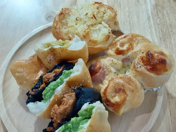 stock image A variety of Thai homemade buns on a wooden chopping board.