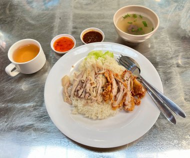 Biber sosu ve tavuk çorbası ile servis edilen pilavlı buğulanmış tavuk.